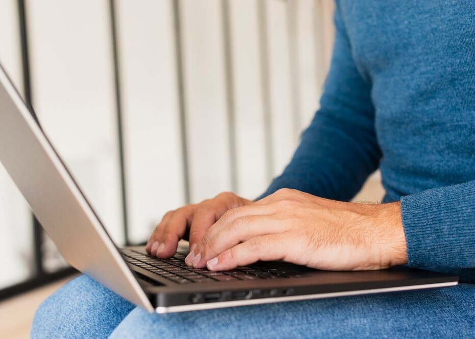 Close-Up of a Man Typing on a Laptop